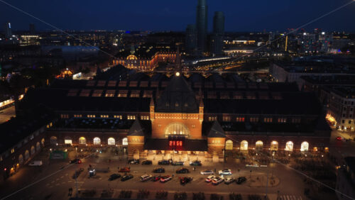 Aerial drone view of the Copenhagen Central Station front view at night with lights in Denmark - Starpik Stock
