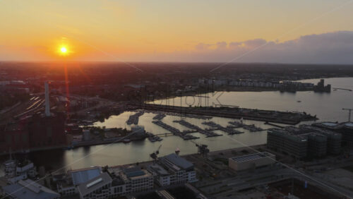 Aerial drone view of the Copenhagen harbor, marina, and sunset over Sydhavnen, Denmark - Starpik Stock