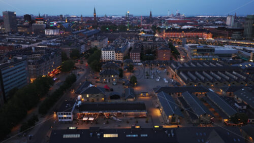 Aerial drone view of the Meatpacking District lit up with lively restaurants, set against Tivoli’s glowing rides in the city center - Starpik Stock