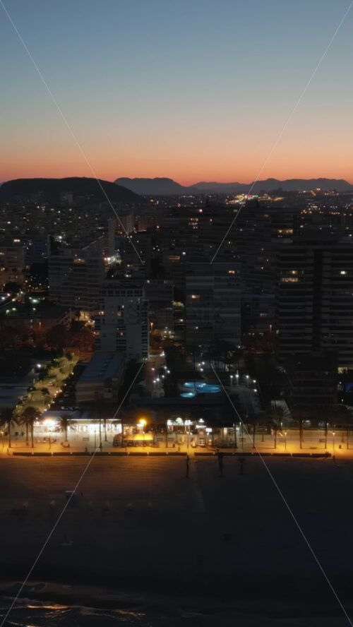 Aerial drone view of the Mediterranean Sea and the Alicante city in Spain at sunset. Vertical - Starpik Stock