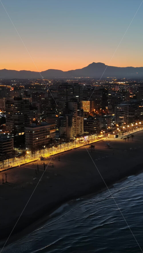 Aerial drone view of the Mediterranean Sea and the Alicante city in Spain at sunset. Vertical - Starpik Stock
