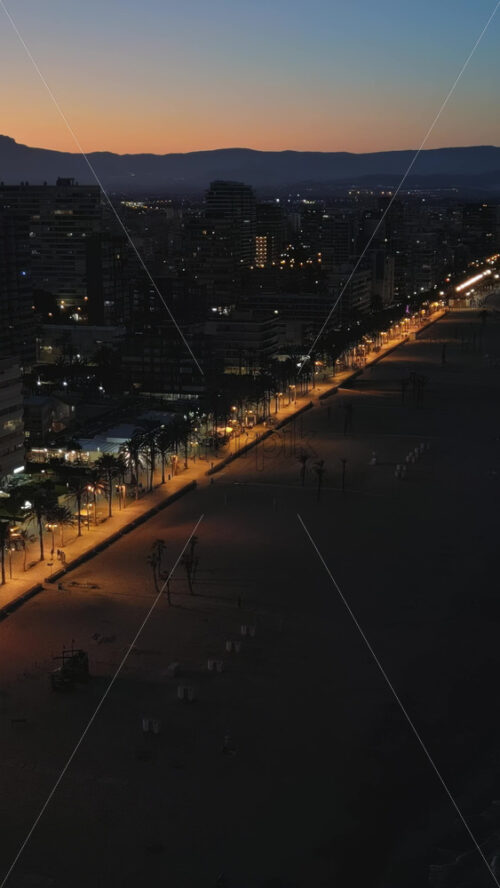 Aerial drone view of the Mediterranean Sea and the Alicante city in Spain at sunset. Vertical - Starpik Stock