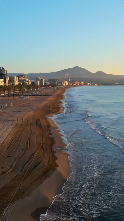 Aerial drone view of the Mediterranean Sea and the city of Alicante, Spain at sunset. Vertical - Starpik Stock