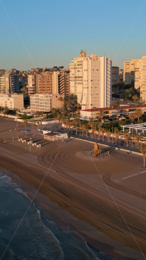 Aerial drone view of the Mediterranean Sea and the city of Alicante, Spain at sunset. Vertical - Starpik Stock