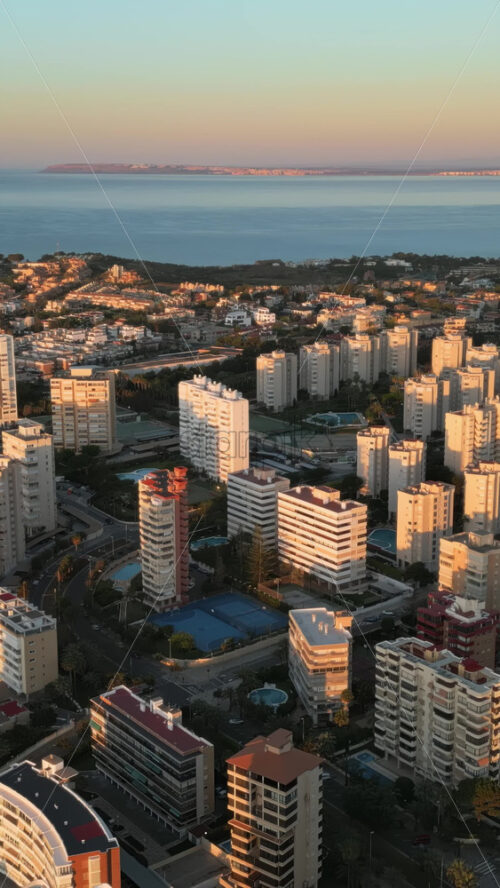 Aerial drone view of the Mediterranean Sea and the city of Alicante, Spain at sunset. Vertical - Starpik Stock