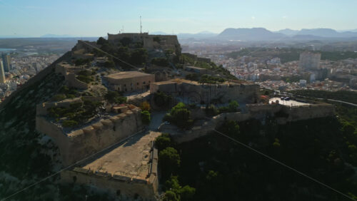 Aerial drone view of the Santa Barbara Castle on the coast of Alicante, Spain with the city and the sea on the background - Starpik Stock
