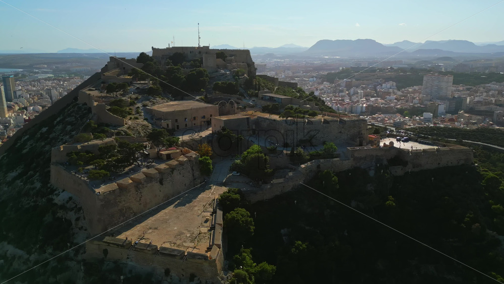 Aerial drone view of the Santa Barbara Castle on the coast of Alicante, Spain with the city and the sea on the background - Starpik Stock