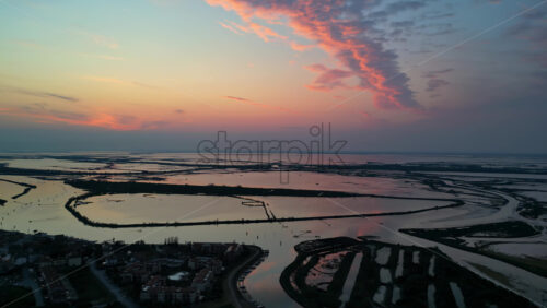 Aerial drone view of the Venetian Lagoon at sunset, near Cavallino-Treporti in northern Italy - Starpik Stock