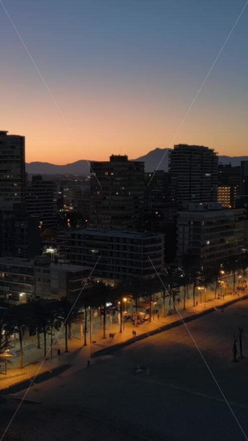 Aerial drone view of the beach and the Alicante city in Spain at sunset. Vertical - Starpik Stock