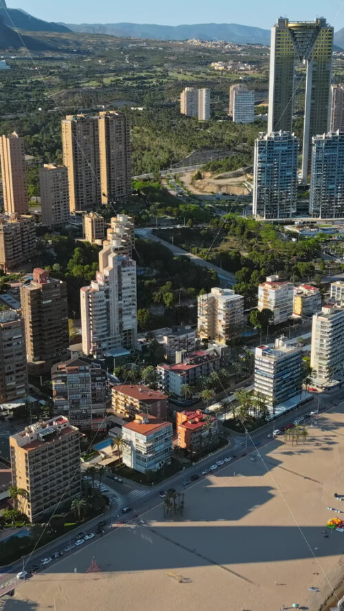 Aerial drone view of the buildings along the coastline and the sea in Benidorm, Spain in daylight. Vertical - Starpik Stock