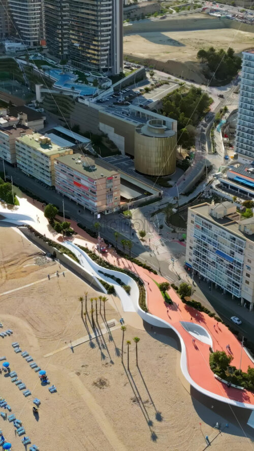 Aerial drone view of the buildings along the coastline and the sea in Benidorm, Spain in daylight. Vertical - Starpik Stock