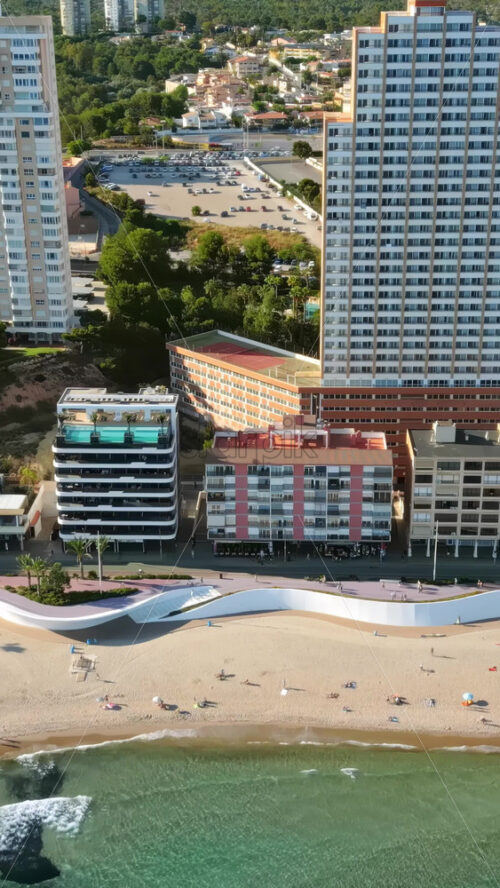 Aerial drone view of the buildings along the coastline and the sea in Benidorm, Spain in daylight. Vertical - Starpik Stock