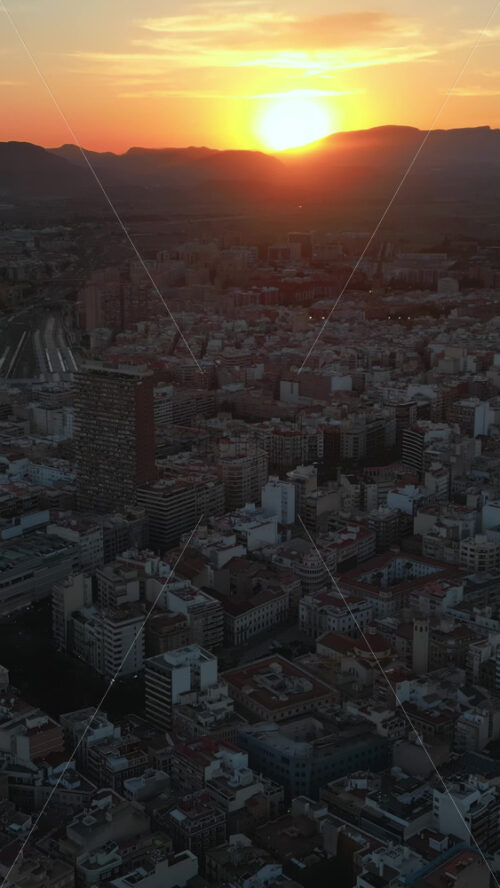 Aerial drone view of the buildings in Alicante, Spain at sunset. Vertical - Starpik Stock