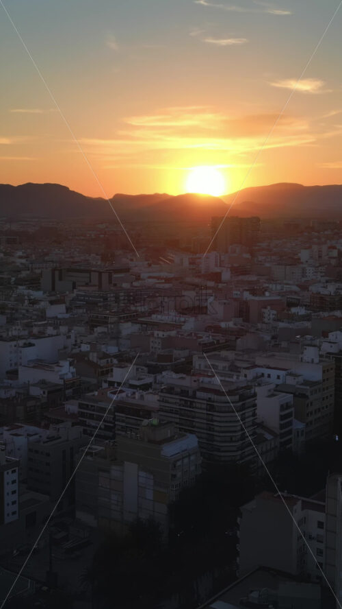 Aerial drone view of the buildings in the city at sunset. Vertical - Starpik Stock