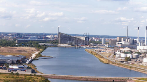 Aerial drone view of the coastline near Amager Strandpark, with sailboats in the water and CopenHill visible in the distance in Copenhagen, Denmark - Starpik Stock