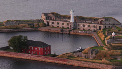 Aerial drone view of the historic Trekroner Fort with its lighthouse and old military buildings by the sea in Copenhagen, Denmark - Starpik Stock