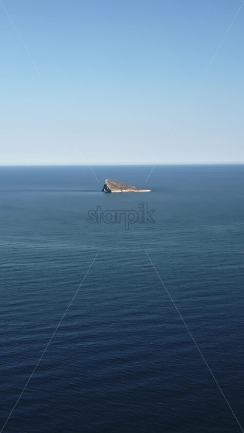 Aerial drone view of the small Benidorm Island and nature reserve on the Mediterranean Sea in Benidorm, Spain. Vertical - Starpik Stock