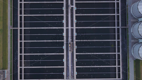 Aerial drone view of the wastewater treatment facility with long water basins and processing structures in Copenhagen, Denmark - Starpik Stock