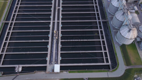 Aerial drone view of the wastewater treatment facility with long water basins and processing structures in Copenhagen, Denmark - Starpik Stock