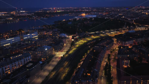 Aerial drone view over Copenhagen with lakes and city lights glowing, showcasing Osterbro and Nordhavn in the background at night in Denmark - Starpik Stock