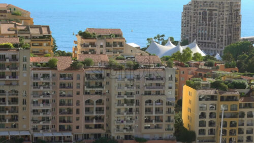 Aerial view of Fontvieille Harbour in Monaco, showcasing its pastel-colored buildings, luxury yachts, and the Mediterranean Sea - Starpik Stock