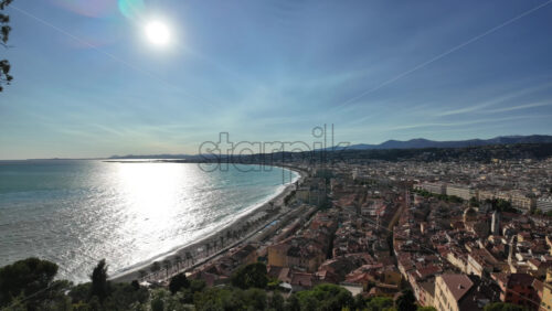 Aerial view of Nice, France with red tiled rooftops, sweeping bay, and mountain backdrop - Starpik Stock