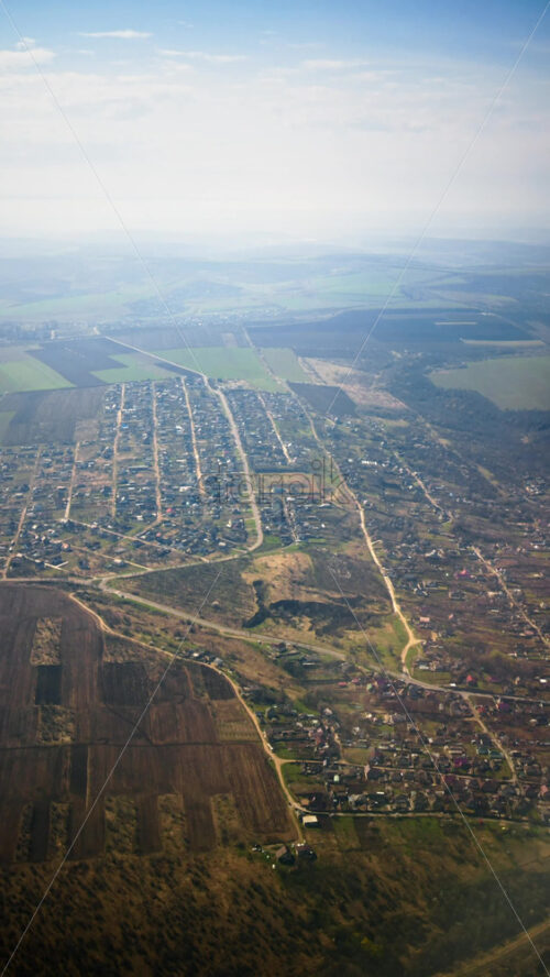 Aerial view of fields and towns from an airplane window. Vertical - Starpik Stock