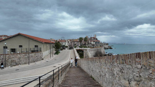 Antibes, France – July 14, 2025: View of people walking near different buildings on the coast - Starpik Stock
