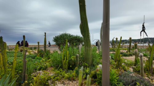 Antibes, France – July 20, 2025: People walking on the coast, near the bronze sculptures by Nicolas Lavarenne - Starpik Stock