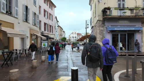 Antibes, France – July 20, 2025: People walking on the streets of the city in the rain - Starpik Stock