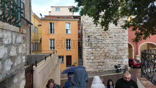Antibes, France – July 20, 2025: People walking on the streets of the city in the rain - Starpik Stock
