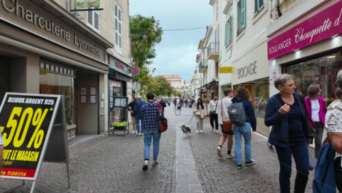 Antibes, France – July 20, 2025: People walking on the streets of the city on a cloudy day - Starpik Stock