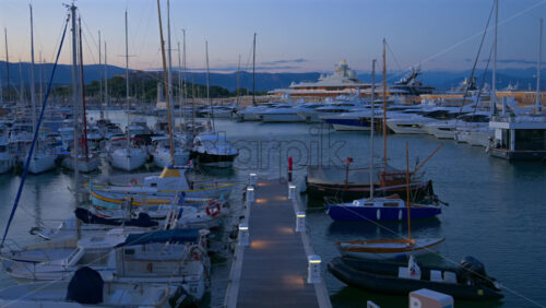 Antibes, France – June 7, 2025: Multiple white boats docked in the Port Vauban with the Fort Carre on the background in the evening - Starpik Stock