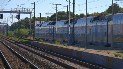 Antibes, France – June 7, 2025: Train moving on the rails, passing by a station - Starpik Stock