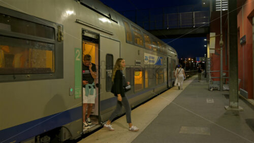 Antibes, France – June 8, 2025: People getting off the train at the station in the evening - Starpik Stock