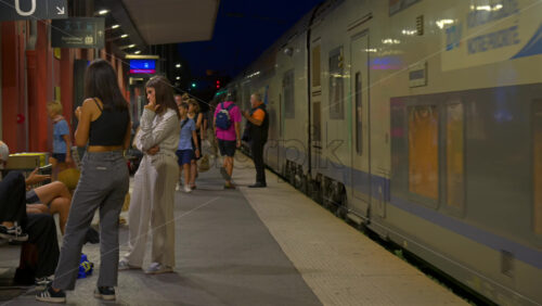 Antibes, France – June 8, 2025: People waiting at the train station in the evening - Starpik Stock