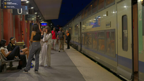 Antibes, France – June 8, 2025: People waiting at the train station in the evening - Starpik Stock
