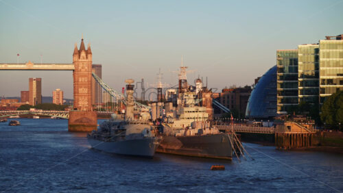 Beautiful sunset over the Thames River featuring Tower Bridge and the HMS Belfast warship, London, England - Starpik Stock