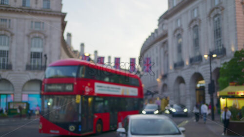 Blurred view of a crowded street near Piccadilly Circus with flags and traffic in London, England - Starpik Stock