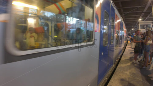 Cannes, France – July 10, 2025: Blue and white regional train pulls through a covered station platform - Starpik Stock