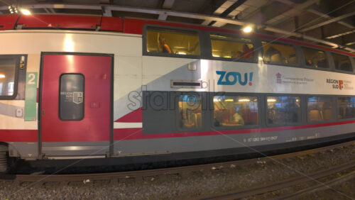 Cannes, France – July 10, 2025: Blue and white regional train pulls through a covered station platform - Starpik Stock