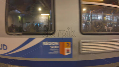 Cannes, France – July 10, 2025: Blue and white regional train pulls through a covered station platform - Starpik Stock