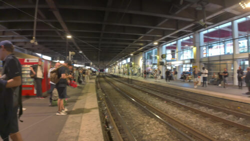 Cannes, France – July 10, 2025: Passengers waiting as regional train pulls through a covered station platform - Starpik Stock