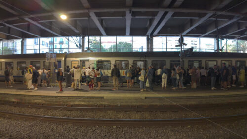 Cannes, France – July 10, 2025: Passengers waiting as regional train pulls through a covered station platform - Starpik Stock