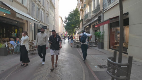 Cannes, France – July 10, 2025: People walking on the streets of the city, near terraces in daylight - Starpik Stock