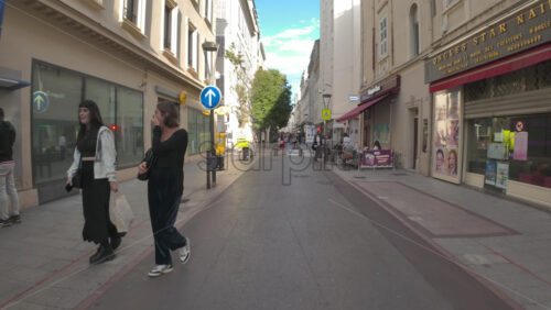 Cannes, France – July 10, 2025: People walking on the streets of the city, near terraces in daylight - Starpik Stock