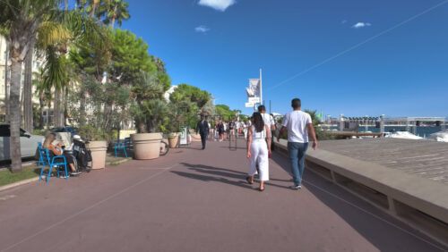 Cannes, France – July 10, 2025: People walking on the streets of the city, near the beach in daylight - Starpik Stock