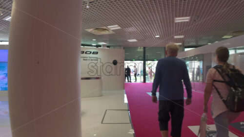 Cannes, France – July 10, 2025: Visitors browsing inflatable RIBs and small boats on either side of a red-carpet aisle beneath a grid ceiling - Starpik Stock