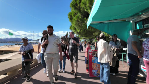 Cannes, France – July 12, 2025: People walking along the seafront on a sunny day - Starpik Stock