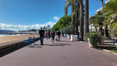 Cannes, France – July 12, 2025: People walking along the seafront on a sunny day - Starpik Stock